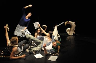 Group of dancer surrounded by rope lights and papers