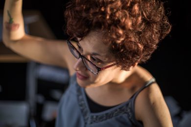 Torso and head of dancer leans towards camera