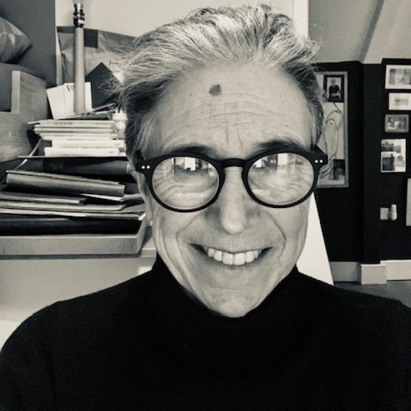 A black and white image of a woman from the shoulders up. She is smiling at the camera.